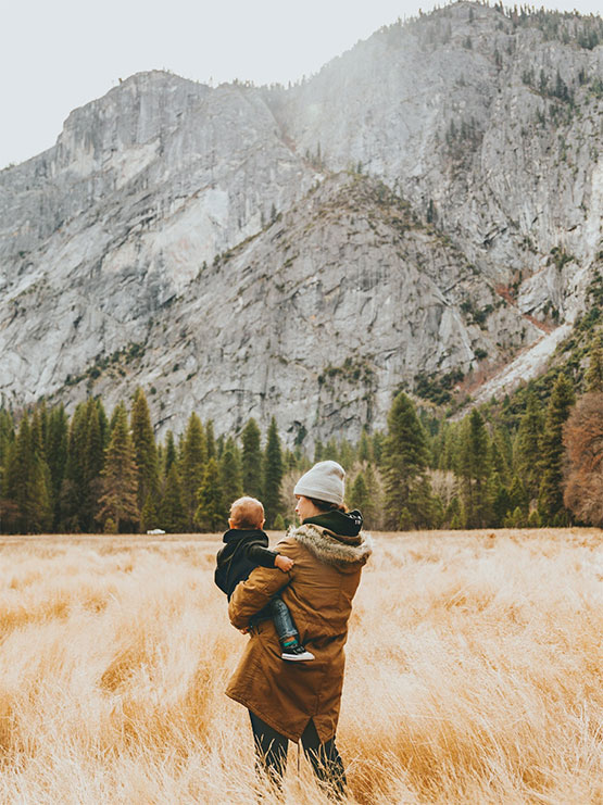 Woman holding children in mountain scene